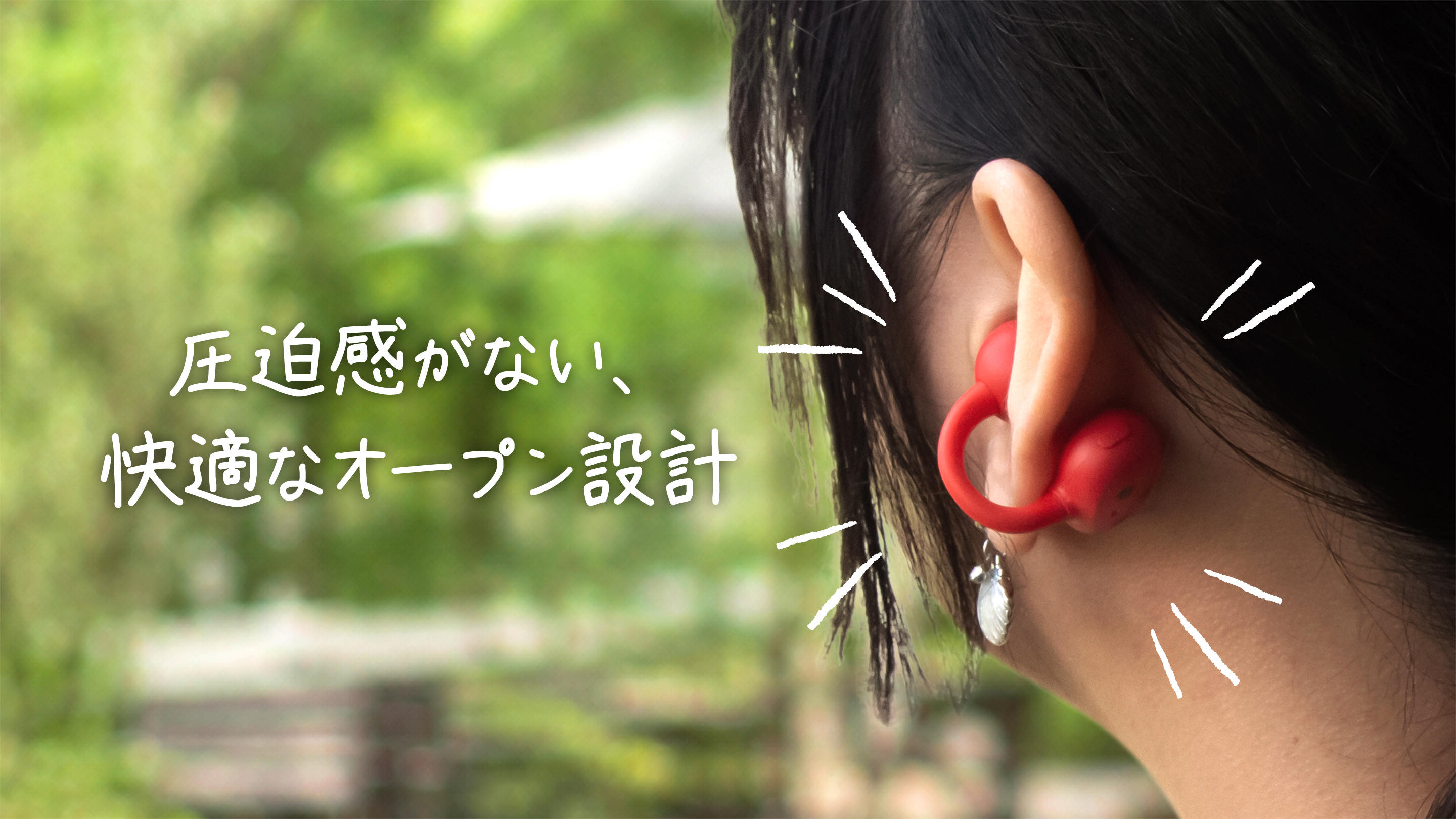 耳に着けた赤いイヤホンのアップ。写真の中の文字『圧迫感がない、快適なオープン設計』